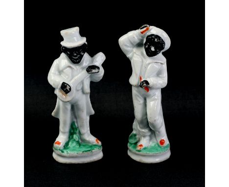 A pair of Staffordshire figures depicting African men, one playing a musical instrument, 9cms high (2).