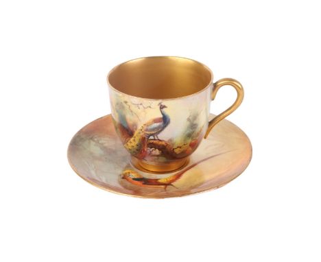 A Royal Worcester cabinet cup and saucer, the cup decorated with a peacock, the saucer decorated with a golden pheasant, sign