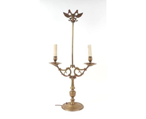 A brass twin-arm table lamp surmounted a twin headed eagle, 73cms high.