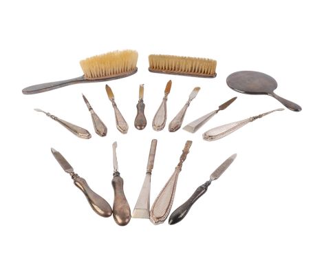 A miniature silver backed hand mirror, Birmingham 1911; together with a quantity of silver handled manicure tools and dressin