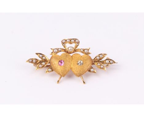 A Victorian 18ct gold double heart brooch set with a diamond and a ruby within a ribbon bow and leaf seed pearl set border, 4
