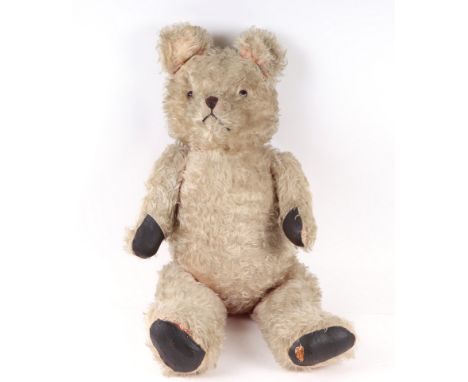 A large vintage straw filled jointed plush teddy bear, 85cms high.Condition ReportWould have originally been pink but colour 