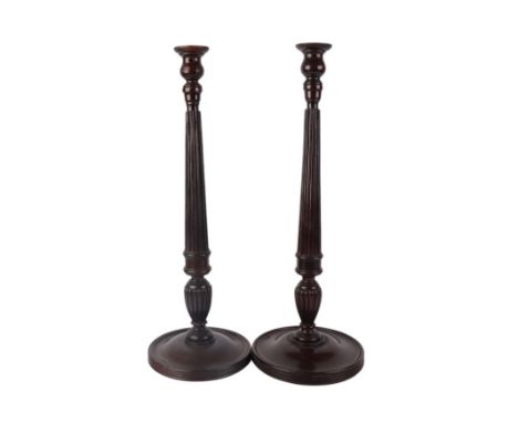 A matched pair of mahogany table lamp bases with turned and reeded columns, on circular bases, 53cms high (2).