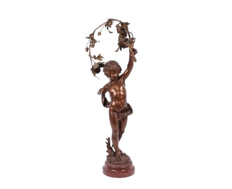 After Auguste Moreau, a very large spelter bronzed lamp in the form of a cherub with a floral garland, on a rouge marble plin