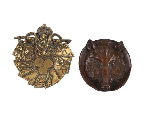 A bronze pin dish in the form of a wolf mask, 11cms diameter; together with another brass example, 12.5cms diameter (2).