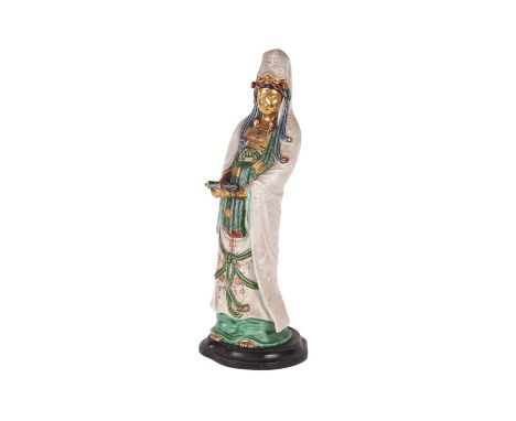 A Chinese pottery figure of Guanyin with gilt and polychrome enamel decoration, on a hardwood stand, 53cms high.