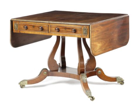 A Regency Irish mahogany sofa table, inlaid with stringing and with gilt brass mounts, the drop-leaf top above twin cedar lin