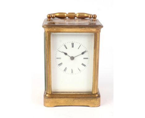 A brass cased carriage clock, the white enamel dial with Roman numerals, the movement striking on a gong, 14cms high.