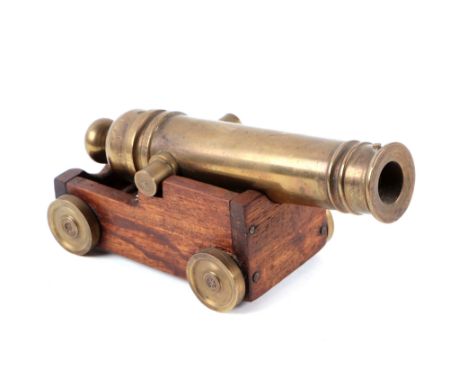 A bronze signal cannon on wooden carriage, barrel length 18cms.