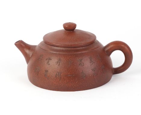 A Chinese Yixing pottery teapot decorated with calligraphy, impressed four character mark to the underside.