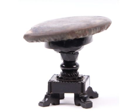 A Whitby jet model of an occasional table with polished ammonite top on a quatrefoil base, 4.5cms high.