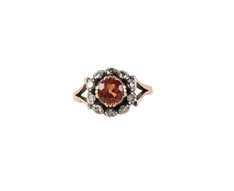 An 18ct gold and white metal ring set with a large pale orange stone surrounded by rose cut diamonds, approx UK size K, 3.5g.