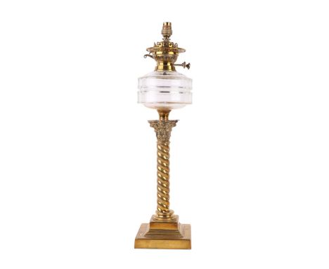 A Victorian brass Corinthian column oil lamp with clear glass reservoir, converted to electricity, 63cms high.