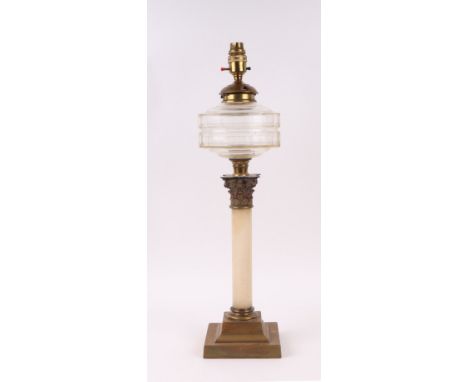A late 19th century oil lamp on a brass and marble Corinthian column with clear glass reservoir, converted to electricity, 51