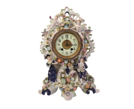 A 19th century continental porcelain flower encrusted mantle clock decorated with figures and cherubs, the white enamel dial 