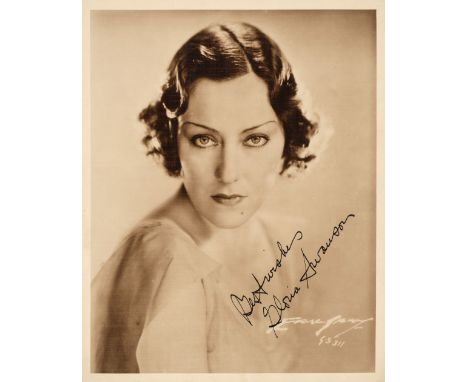 * Swanson (Gloria, 1899-1983). A vintage signed publicity photograph, head and shoulders portrait, signed in blue fountain pe