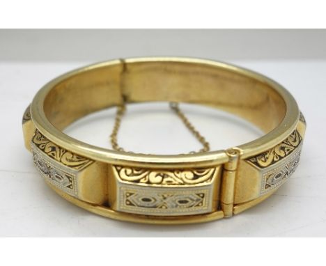 A gilt bangle with safety chain