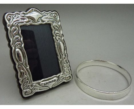 A silver photograph frame and a bangle, the frame marked 999
