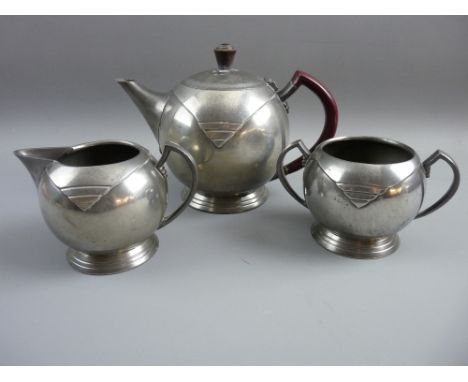 A WARRIC ART DECO THREE PIECE PEWTER TEASET, bullet shaped teapot with bakelite handle and finial with pattern in relief on a