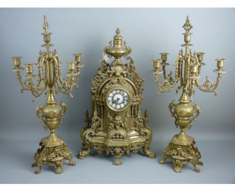 A LOUIS XVI STYLE BRASS CLOCK GARNITURE, the bell striking movement behind a brass and enamel dial set with Roman numerals, t