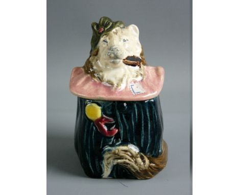 A CONTINENTAL MAJOLICA TOBACCO JAR in the form of a dog in costume with a pink ruff, 13 cms high, incised number 2160 to the 