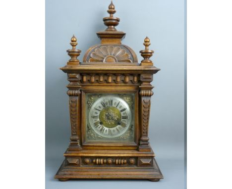 A WALNUT CASED ARCHITECTURAL STYLE MANTEL CLOCK, the silvered dial set with Roman numerals with brass spandrels and pierced c