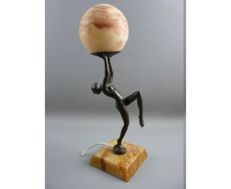 AN ART DECO STYLE FIGURAL LAMP showing a naked female in a dancing pose on a square alabaster base holding an alabaster globe