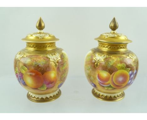 A PAIR OF ROYAL WORCESTER PORCELAIN POT POURRI VASES of globular form with pierced covers, hand painted fruit designs, signed