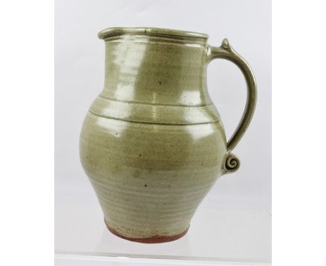 BERNARD LEACH A 1940'S EARTHENWARE STUDIO POTTERY JUG of ringed baluster form with all over celadon glaze, having incised mar