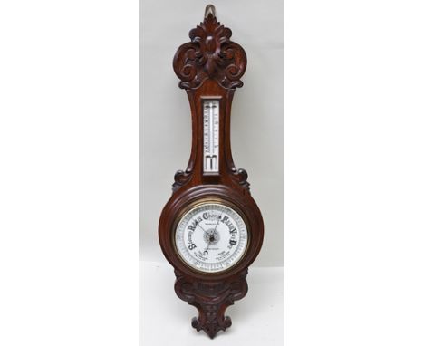 THOMAS WALLIS & CO LTD OF HOLBAN CIRCUS, LONDON AN EDWARDIAN CARVED OAK CASED BAROMETER AND THERMOMETER, overall 76cm high, t