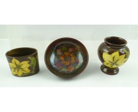 A MOORCROFT CERAMIC SQUAT BALUSTER VASE, piped and painted "Bermuda Lily" design on a chocolate brown ground, 9cm high, toget