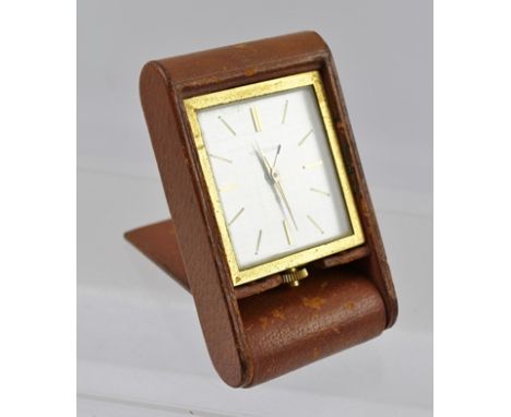 A JAEGER-LE-COULTRE TRAVEL ALARM CLOCK, having manual 8-day movement, brown pig skin covering, baton markers to dial, no. 125