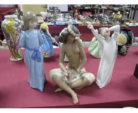 A Lladro 'Yawning Boy' and two Nao figures, including standing girl in a blue dress and a seated Tahitian lady. (3)