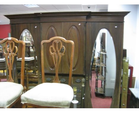 A Mahogany Break Front Triple Wardrobe, moulded pediment over twin astragal recessed panel cupboard doors above drawers, all 