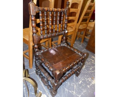 AN EARLY OAK LOW SIDE CHAIR WITH BOBBIN SUPPORTS. SEAT HIGHT 36cms