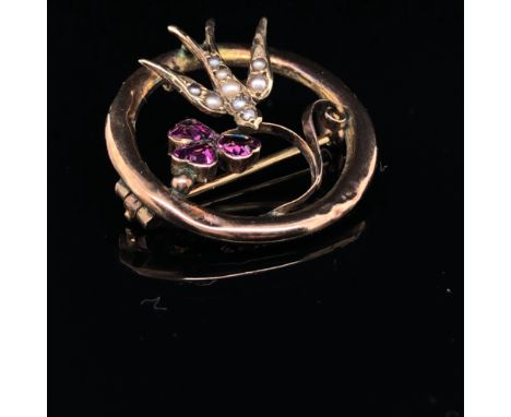A VICTORIAN 9ct GOLD LOVE TOKEN BROOCH. THE SWALLOW SET WITH SEED PEARLS HOLDING A PINK GEMSET CLOVER. 2.5cm DIAMETER, WEIGHT