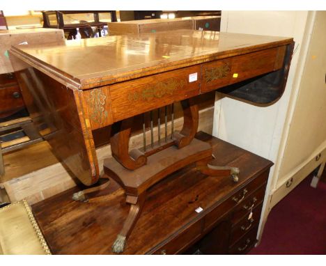 A Regency rosewood and brass inlaid pedestal sofa table, having typical rounded drop ends, twin frize drawers, raised on lyre