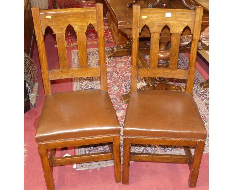 A set of six Arts &amp; Crafts style oak lancet arched slatback dining chairs, each having a tan rexine studded stuffover sea