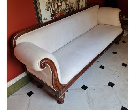 A mid-Victorian mahogany framed and pale fabric upholstered twin scroll-end three-seater sofa, raised on turned supports (one