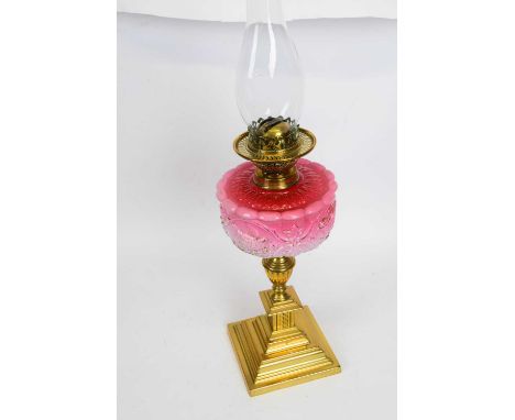 19th century brass oil lamp with pink glass shade, moulded in relief, above brass mounts