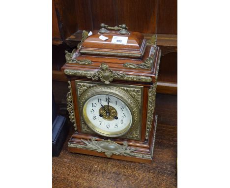 Late 19th or early 20th century mantel or bracket clock, the case with extensive applied brass detail to a porcelain dial wit