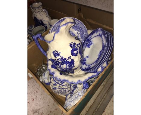A box of blue and white pottery to include large jug and bowl set, plates, large platter, soup dishes, and a small clock etc 