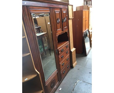 An Edwardian mahogany wardobe with left sided mirror door and right sided cupboard with carved panel doors over  four drawers