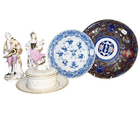 A pair of German porcelain figures in the Meissen style, a Royal Worcester ivory porcelain butter dish, cover and stand, a Ja