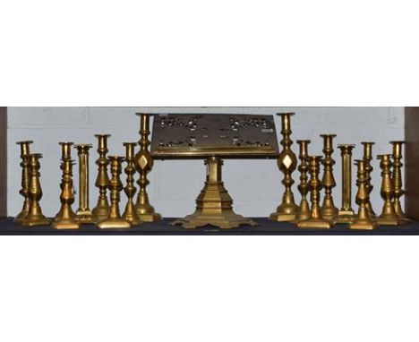 ~A Victorian ecclesiastical brass book stand, pierced and engraved with four saints on a hexagonal stepped base together with