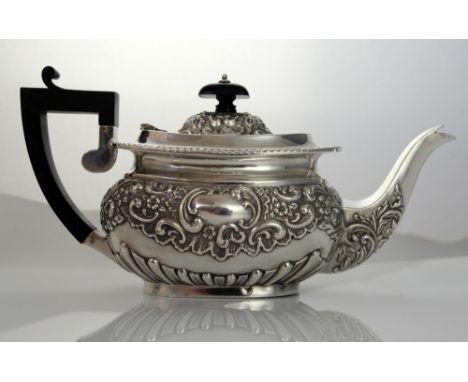 Edward VII silver three piece tea service, comprising tea pot, cream jug and sugar bowl, embossed with scrolling decoration, 