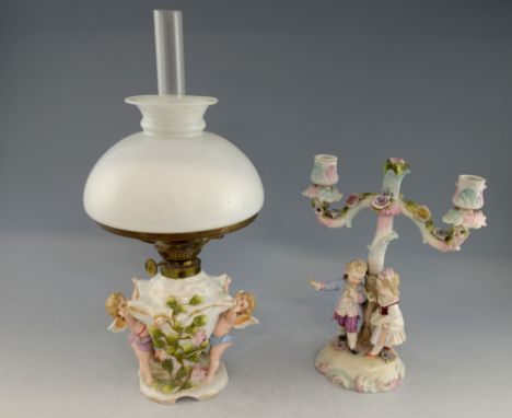 Dresden porcelain figural two branch candelabrum with applied flower decoration, modelled as a girl and boy in Rococco dress 