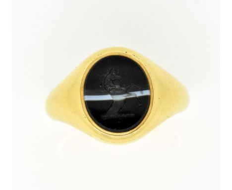 Oval banded agate signet ring, intaglio cut with a rearing horse, mounted in yellow metal testing as 18 ct, ring size L This 