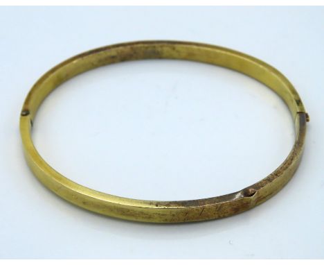 A hinged yellow metal bangle, tests electronically as 15ct gold, 4.8g