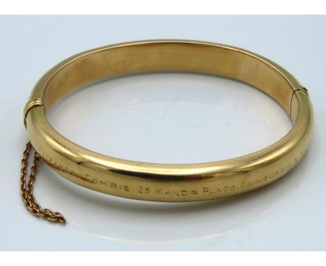 A hinged yellow metal bangle, tests electronically as 9ct gold, inscribed Elizabeth Comrie, 25 Manor Place, Edinburgh, 3-SACB